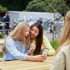 Studenten tijdens de pauze met telefoon Studenten tijdens de pauze