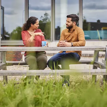 Docenten in overleg aan tuintafel Docenten in overleg aan tuintafel