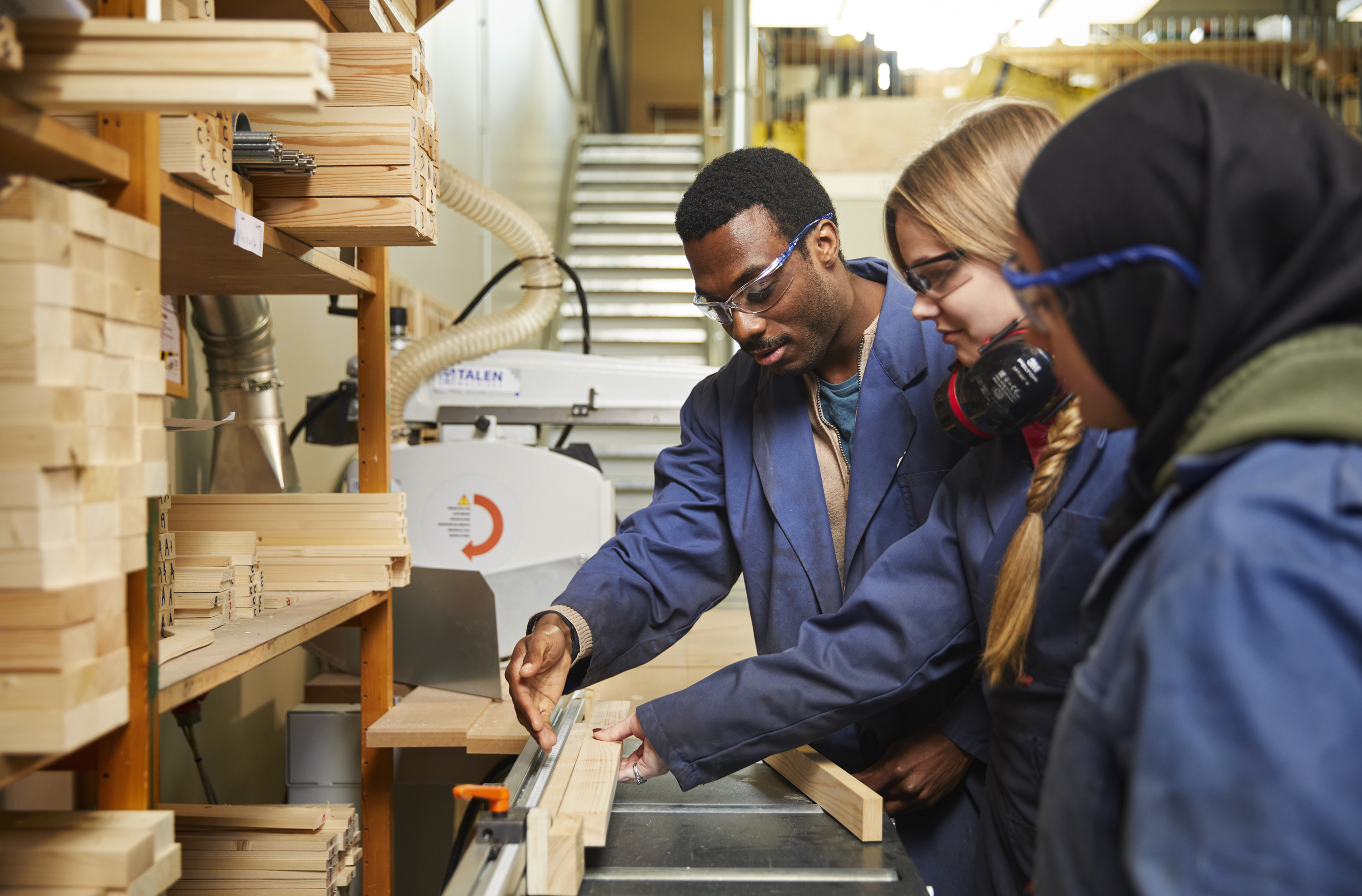 Docent en studenten middelbaar beroepsonderwijs in de werkplaats