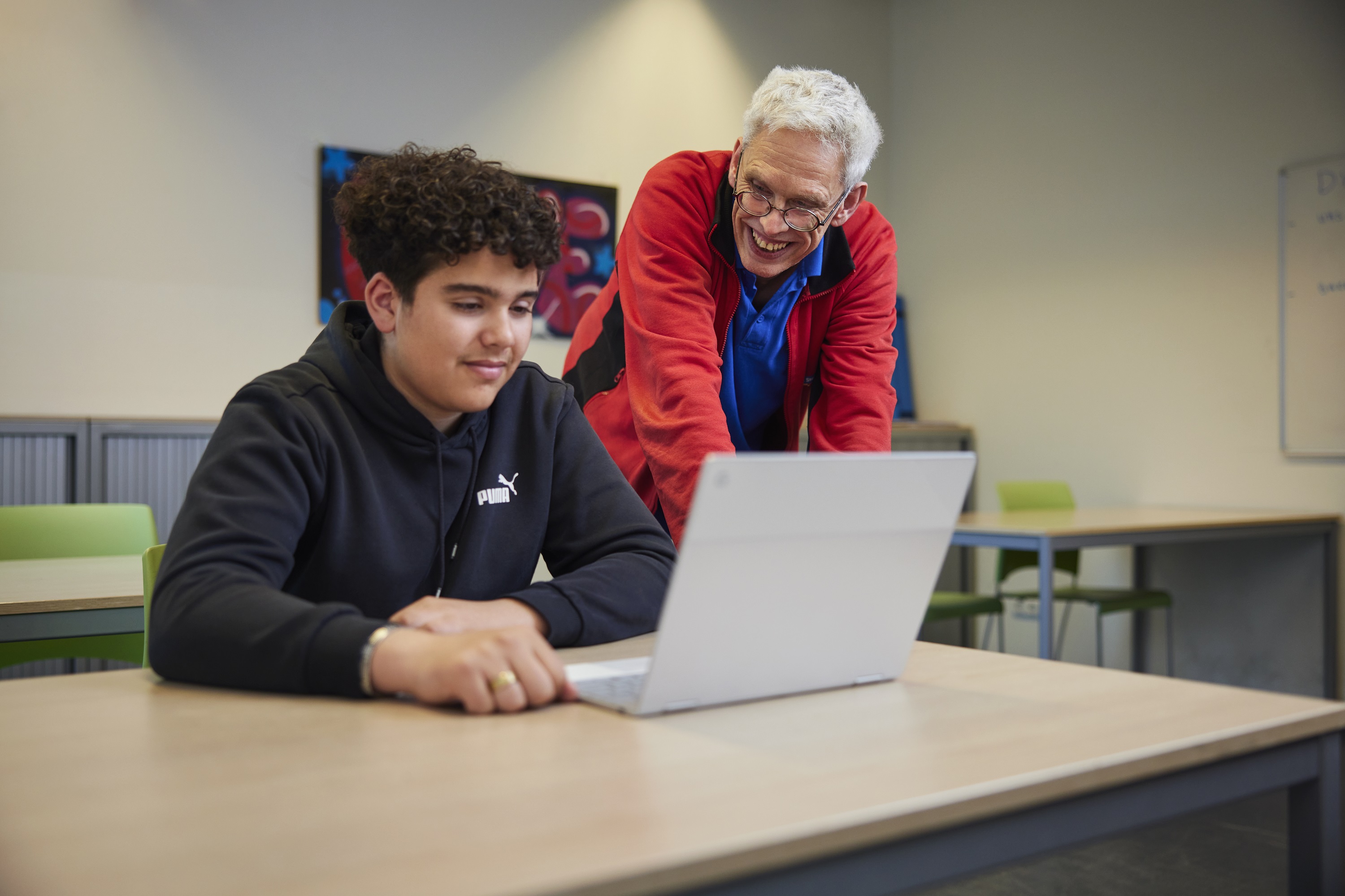 ICT-ondersteuner Tjeerd helpt een bovenbouwleerling met zijn laptop