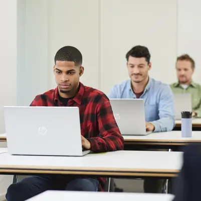Drie mannen maken een digitale toets op een laptop. Drie mannen maken een digitale toets op een laptop.
