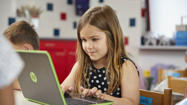 Leerling primair onderwijs achter laptop